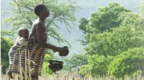 femme béninoise avec son enfant dans un champ 