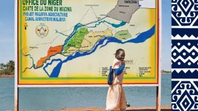 Jeune fille devant un panneau de l'Office du Niger, Mali © Sven Torfinn